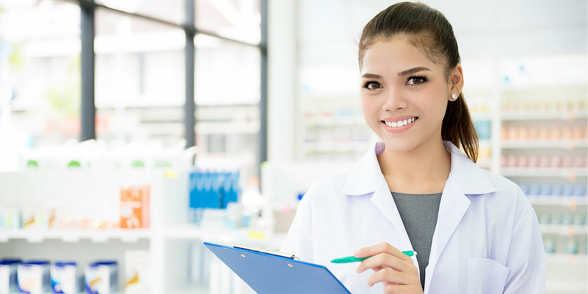 Studentin in einer Apotheke mit Klemmbrett und Stift